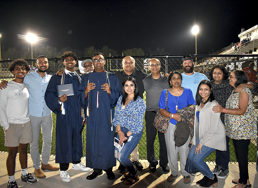 Patel family pose proudly with their graduates.