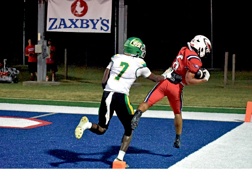 PHOTOS BY GERALD BROWN Receiver Ryheem Moore does a toe-tap on a catch in the end zone for a touchdown. Running back Bryce Manning does a flip as the War Eagles come out of the tunnel to start the game against Suwannee.